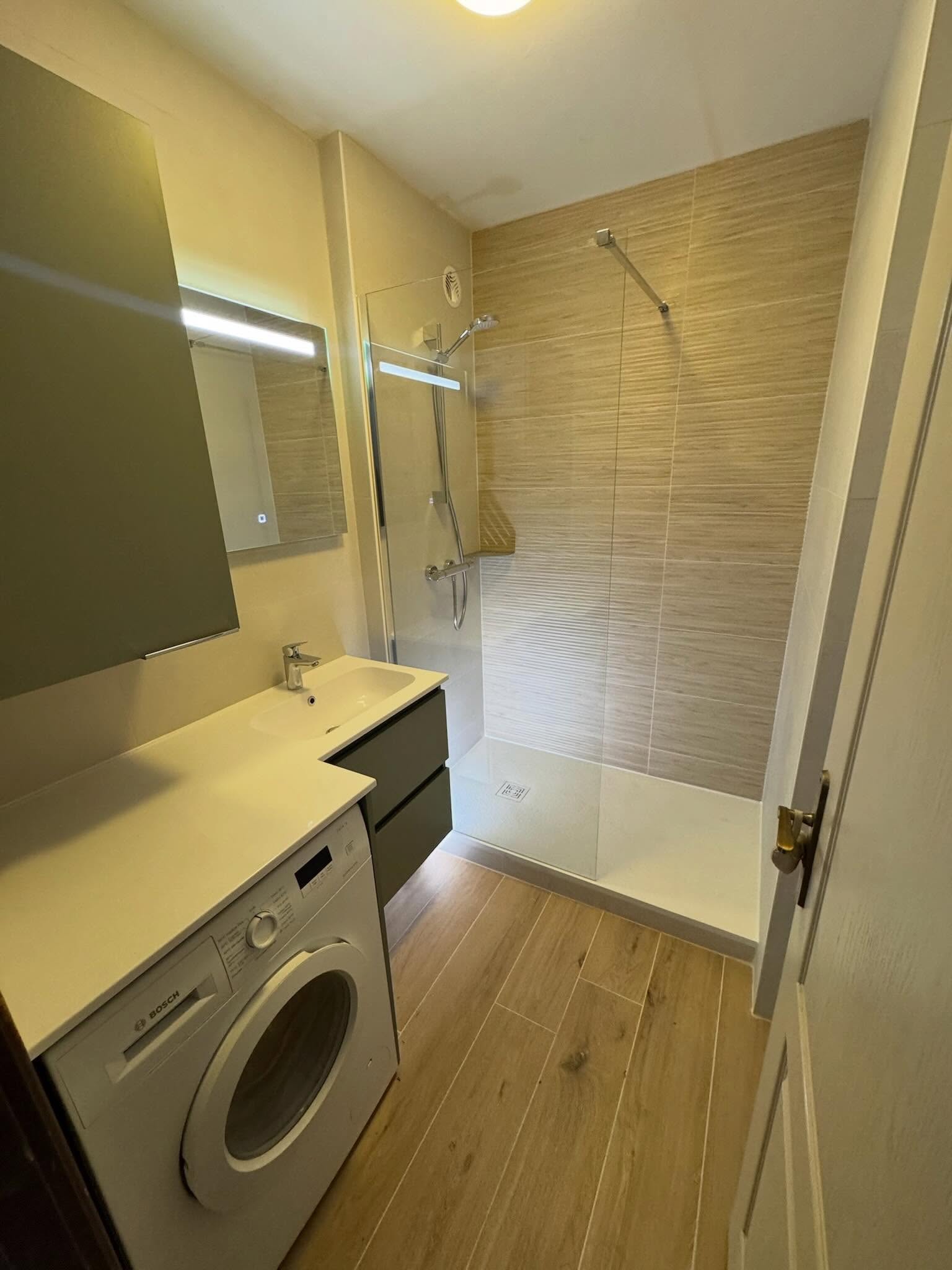 Salle de bain rénovée — douche italienne, plan vasque, parquet.