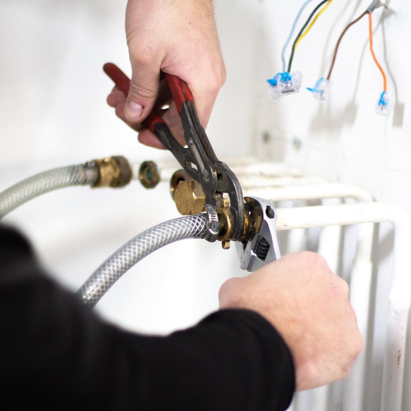 Mains de technicien Rakor reprenant un raccord laiton.