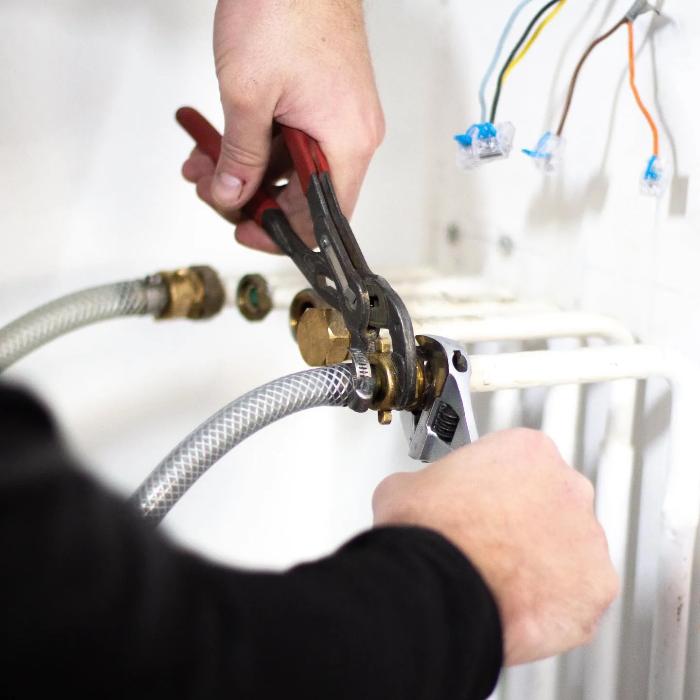 Mains de technicien Rakor reprenant un raccord laiton.
