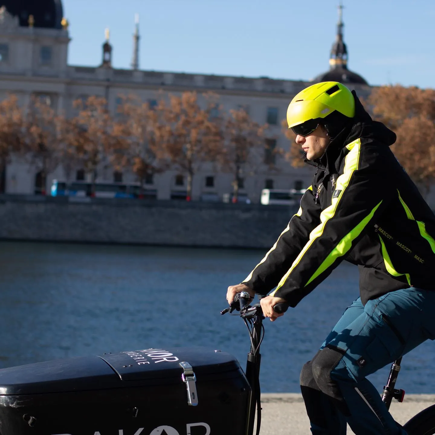 Rémy en livraison sur le triporteur électrique, dôme de l'Hôtel-Dieu en arrière-plan.